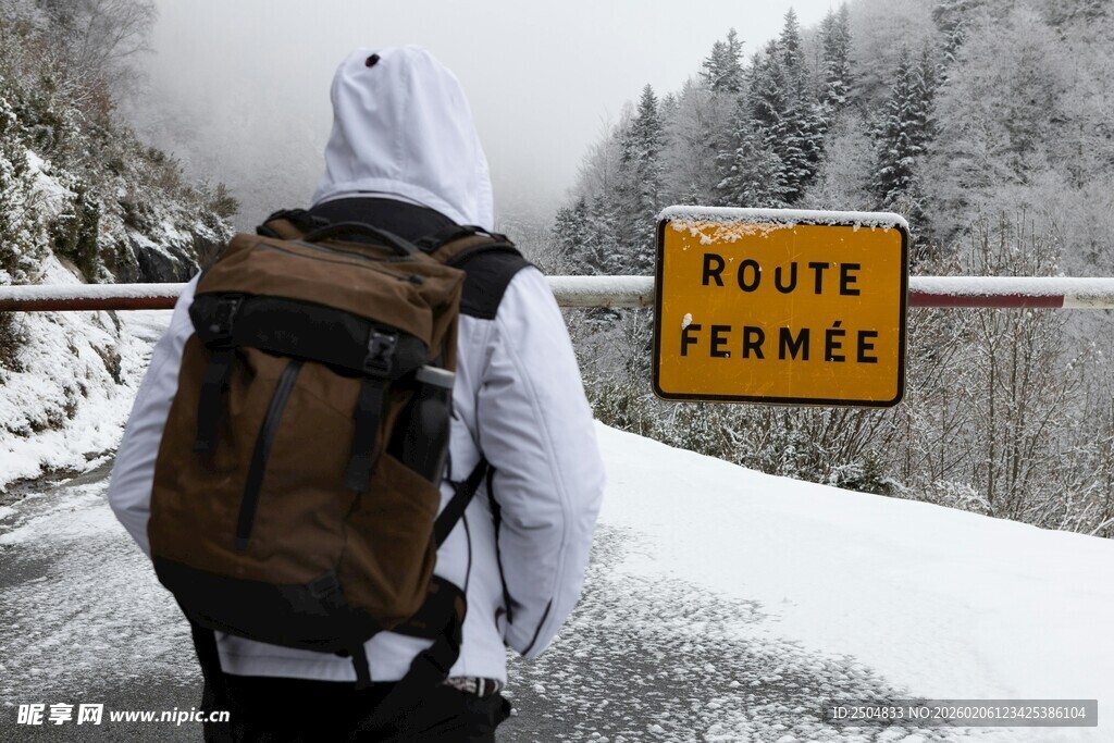 雪地中背包客与公路标志