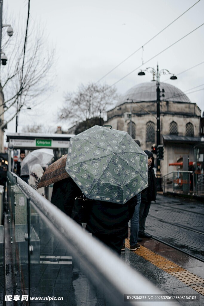 雨中行人撑伞走过街道