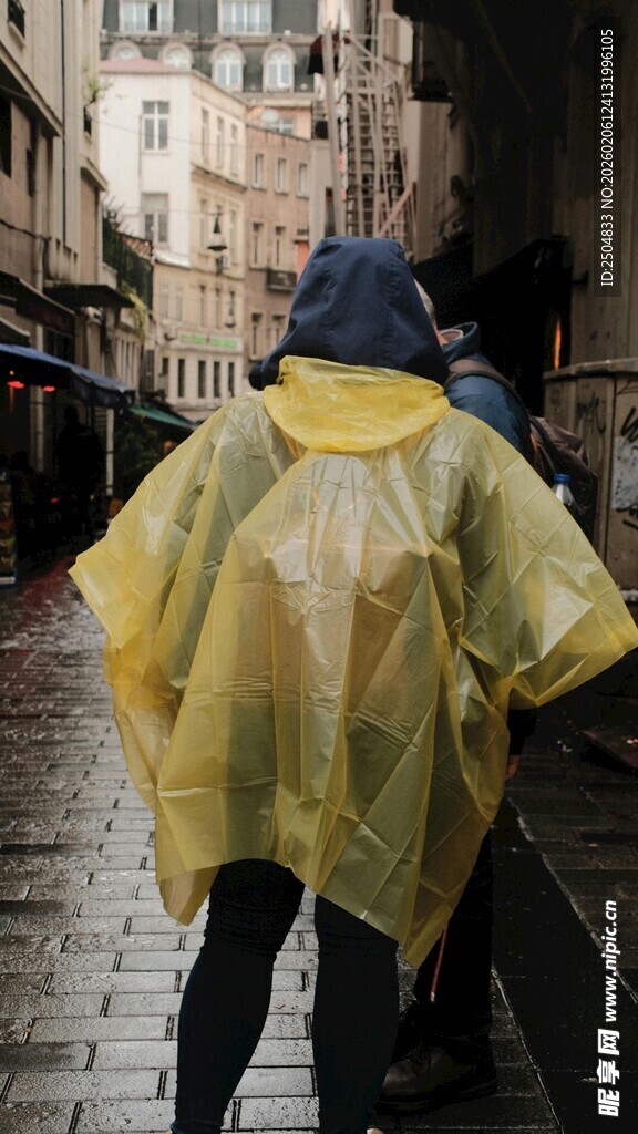 雨中行人穿黄色雨衣漫步