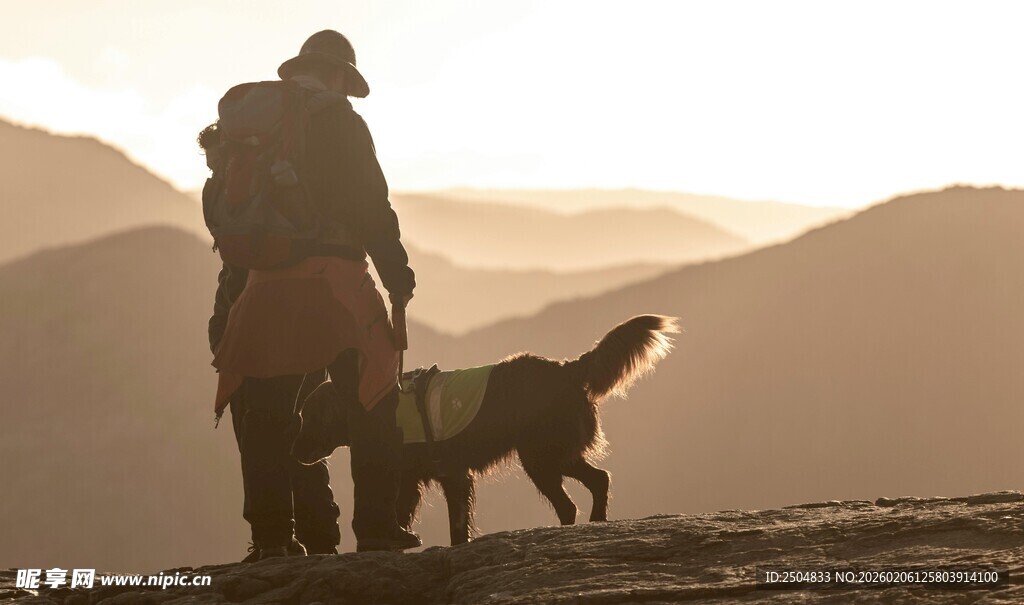 徒步者与狗共赏山间美景