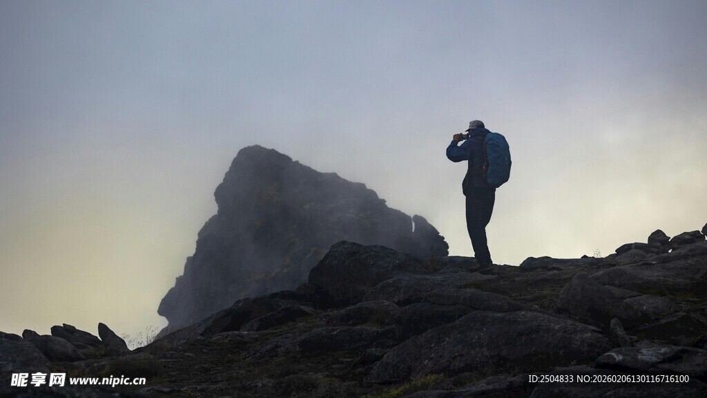登山者于山巅专注摄影