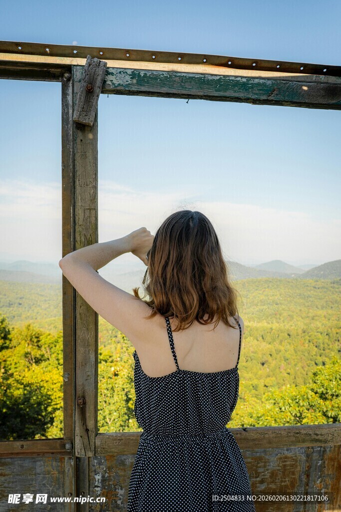 女子凭栏眺望远方美景