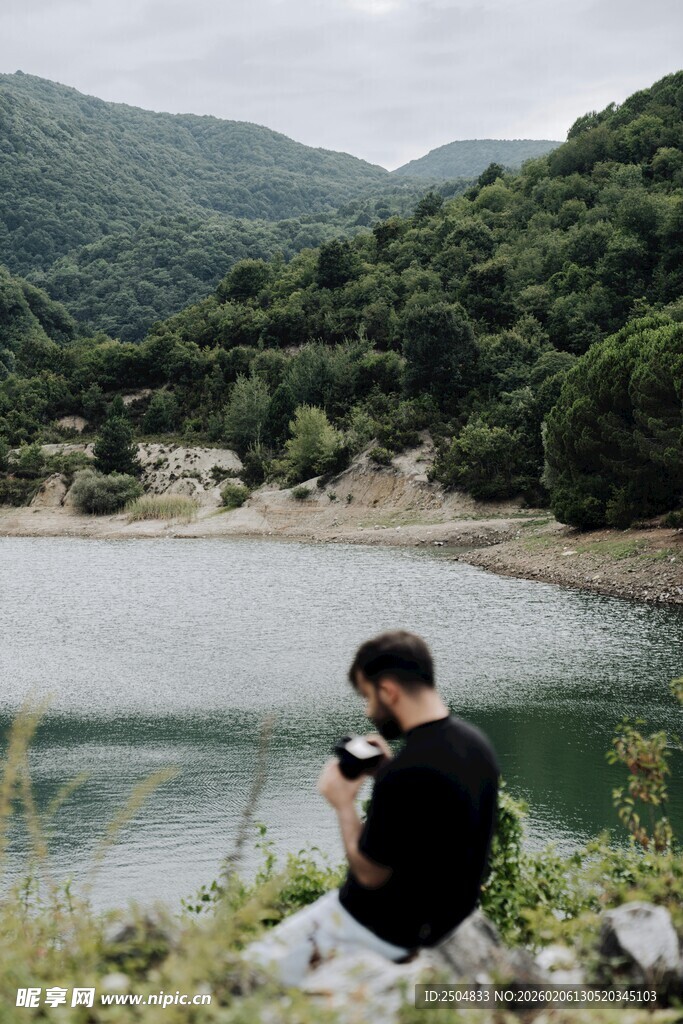 男子静坐在山水间赏景