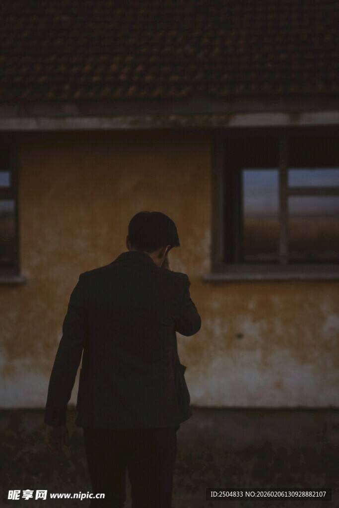 男子于旧屋前打电话