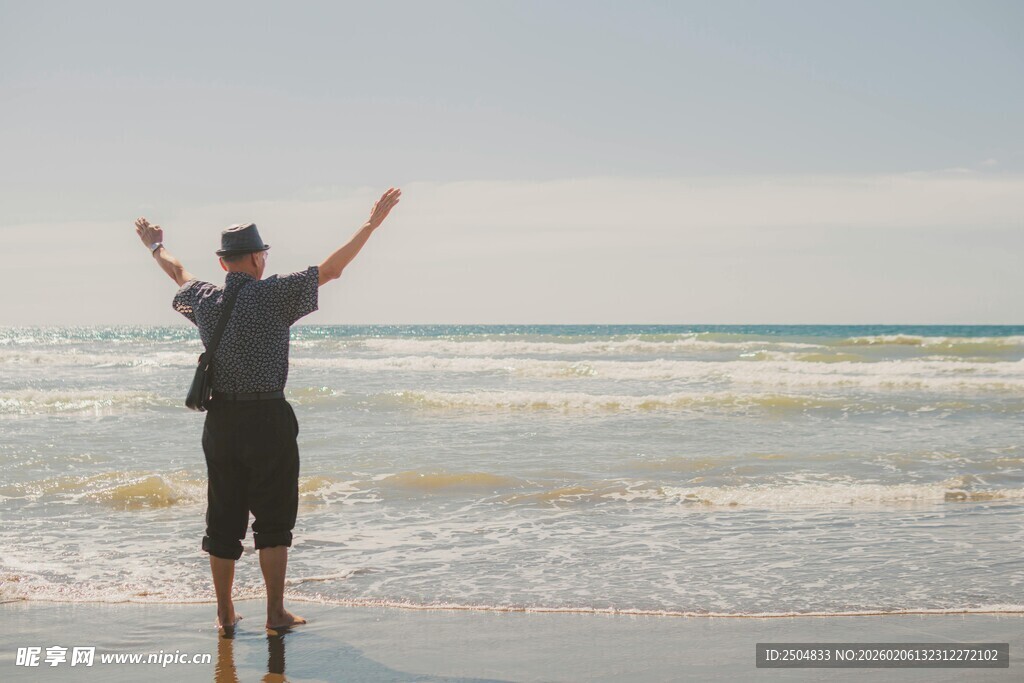 海边男子舒展双臂迎海风