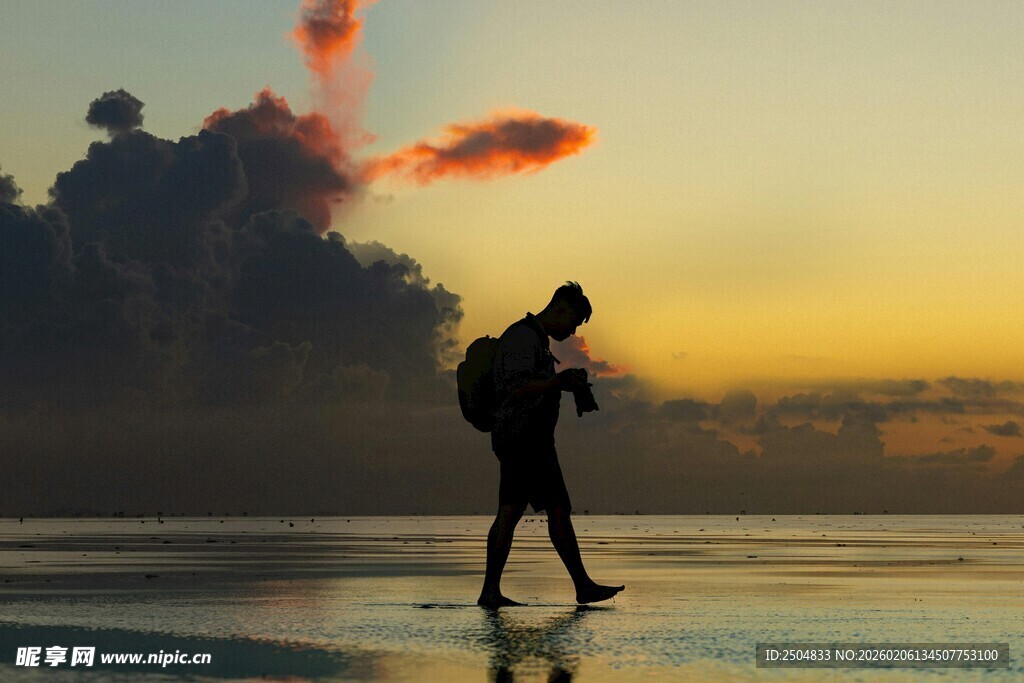 夕阳下徒步的背包旅行者