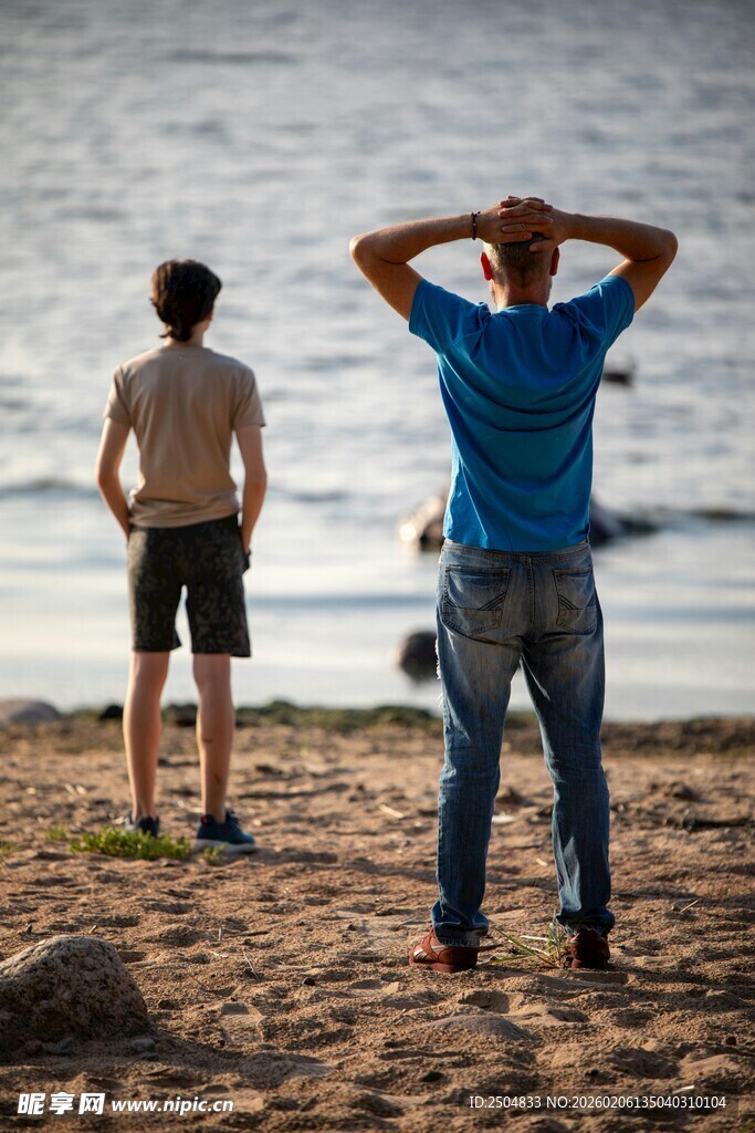 两人海滩上背对镜头而立