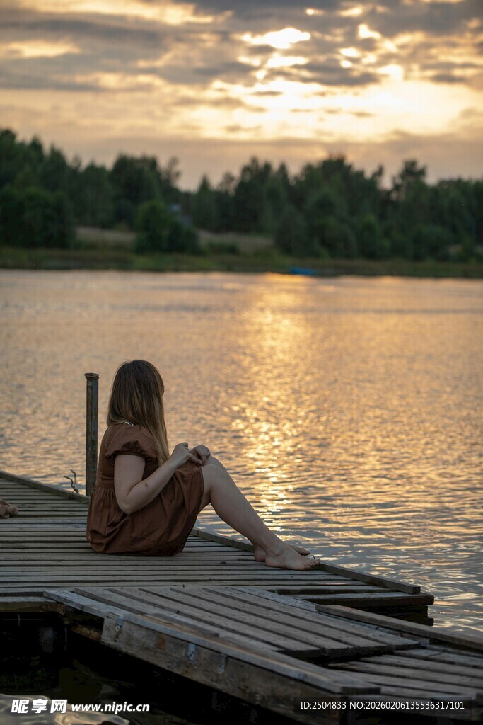 夕阳下独坐码头的孩童