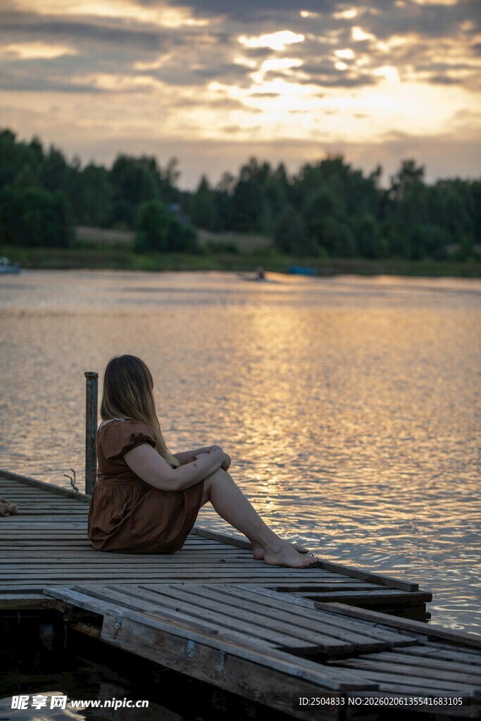 夕阳下独坐码头的女子