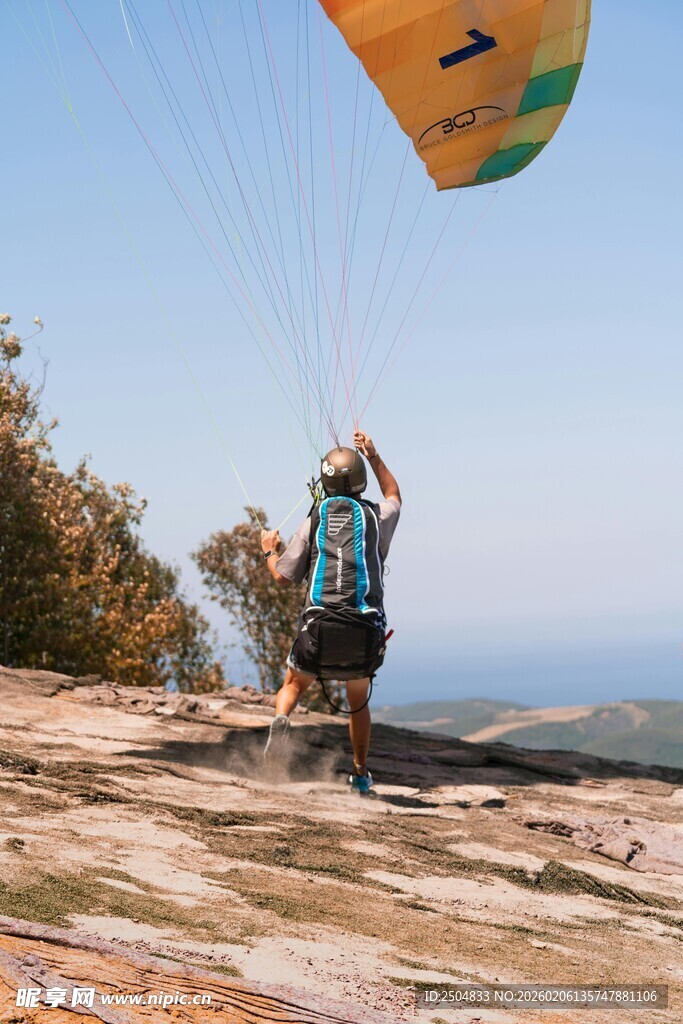 悬崖边准备滑翔的冒险者