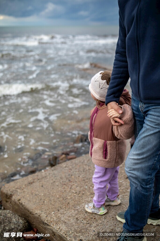 海边父女温馨牵手瞬间