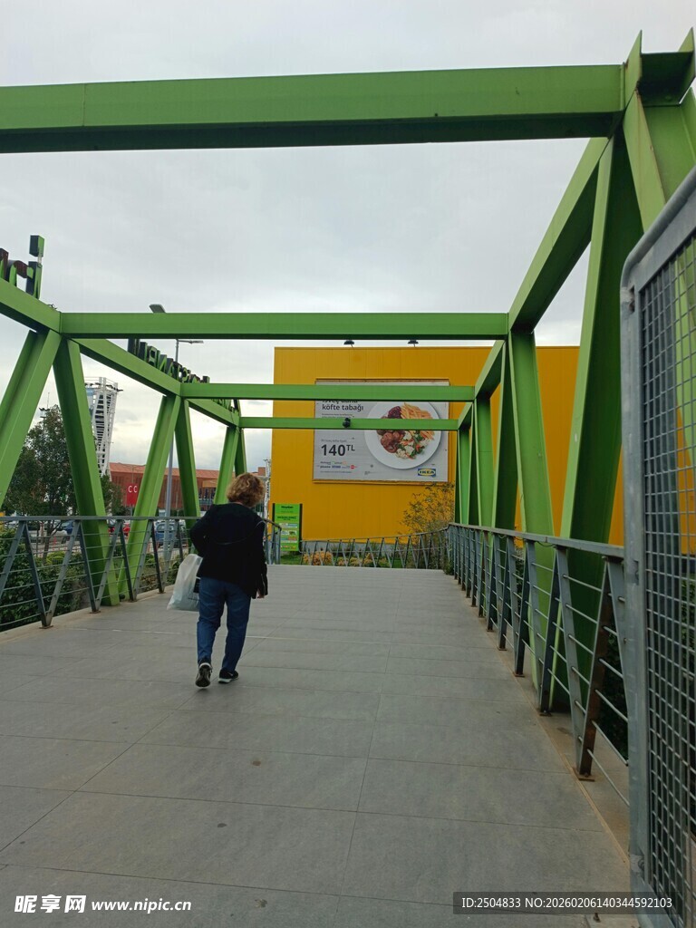 行人漫步于绿色桥梁之上