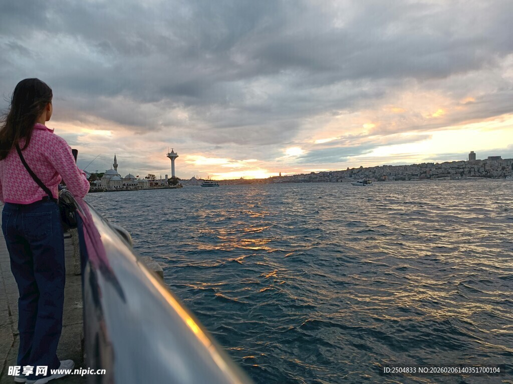 女孩船边赏海上黄昏景色