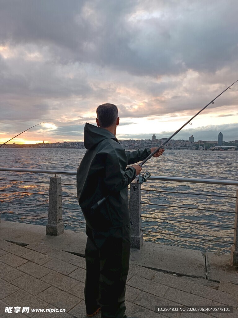 男子码头垂钓赏黄昏美景