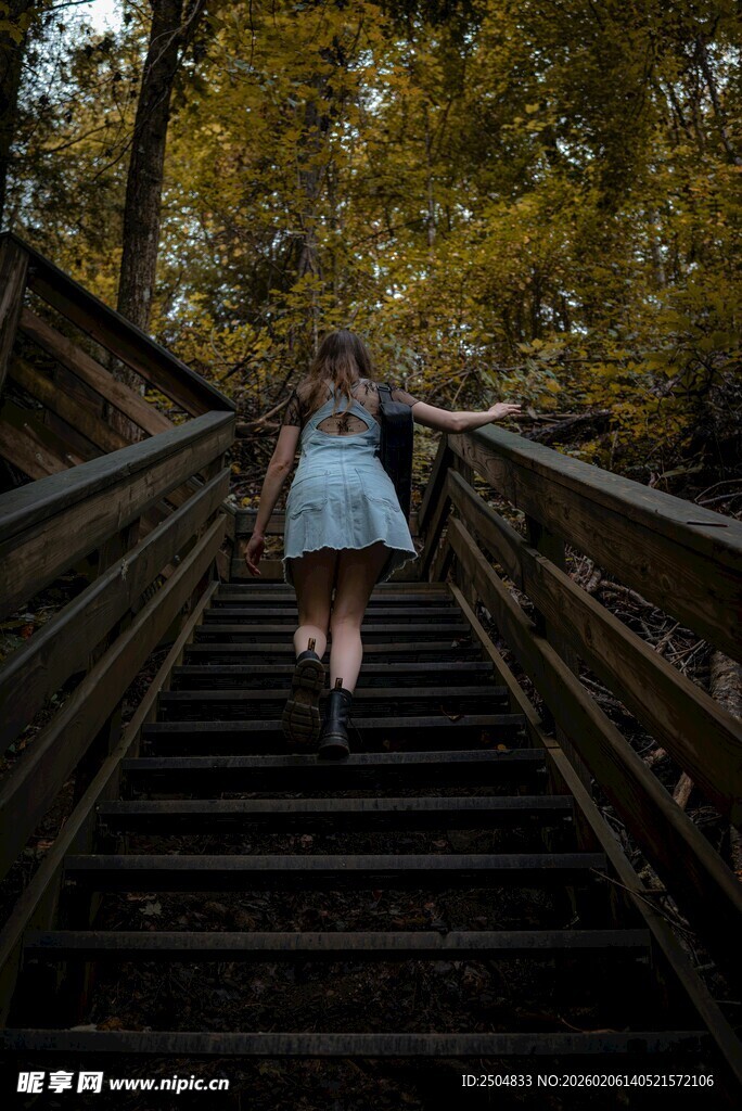 女孩漫步于林间木质阶梯