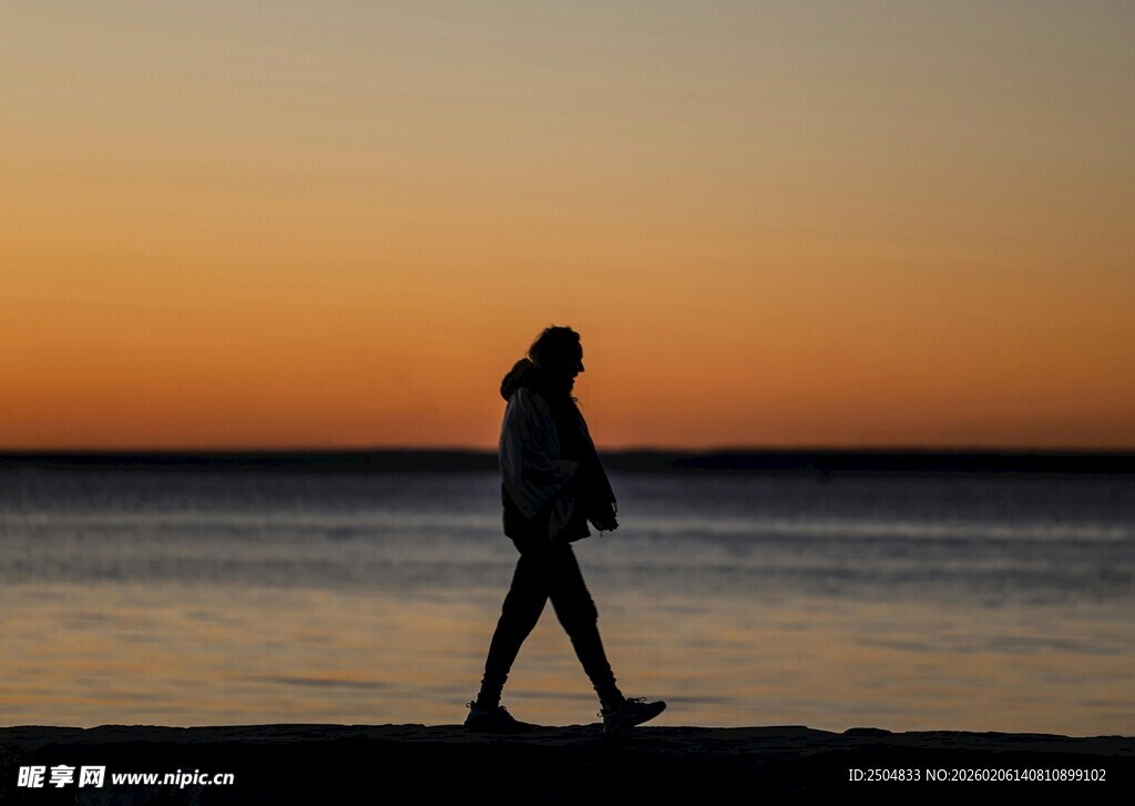 夕阳下海边漫步的身影
