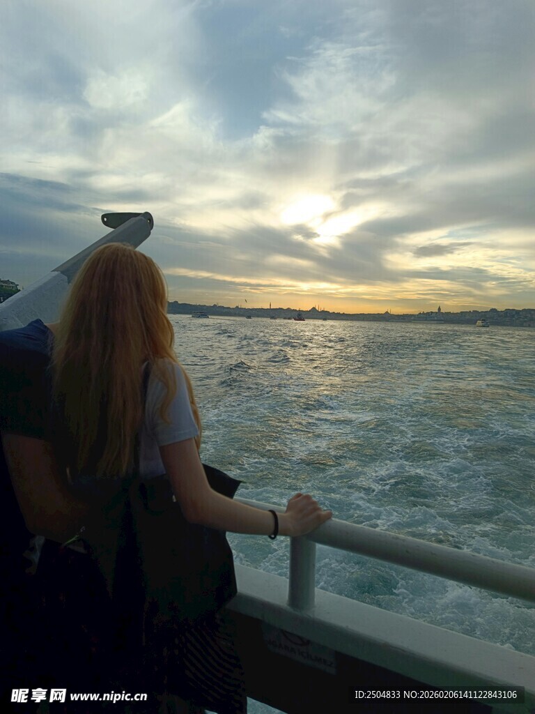 女孩船边赏海上日落美景