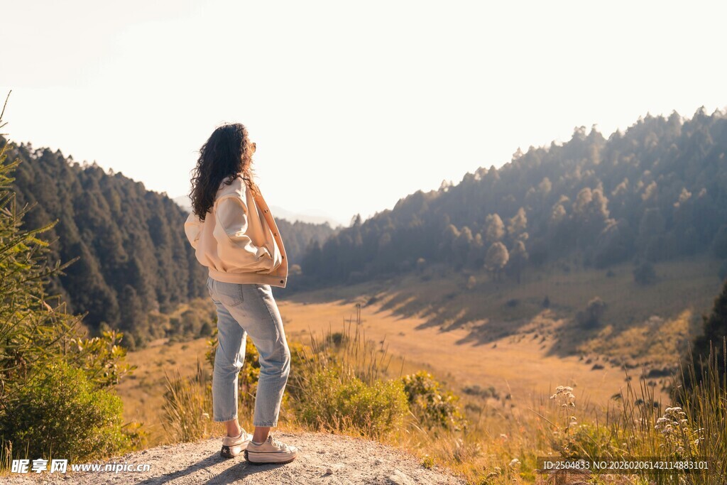 女子立于山间赏壮丽风景