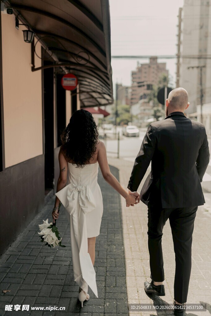 街头牵手的浪漫新婚夫妇