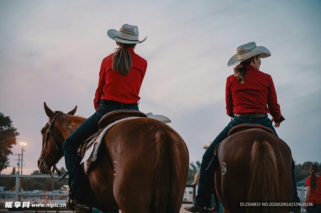 两位红衣牛仔骑马背影