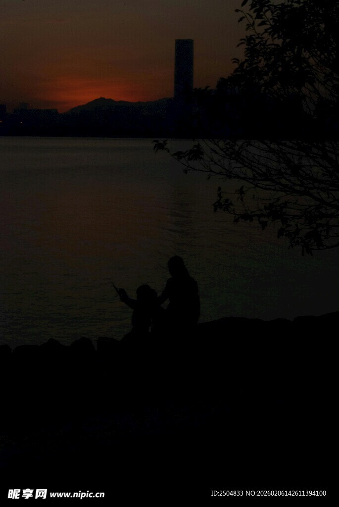 夕阳下湖边的垂钓者