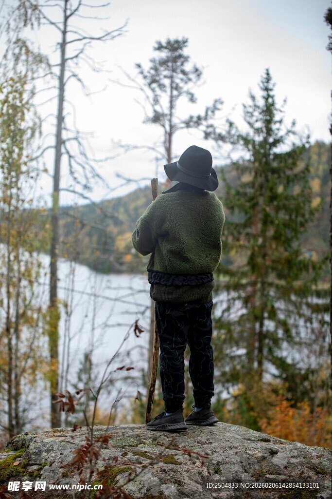 男子湖畔持杖眺望自然景