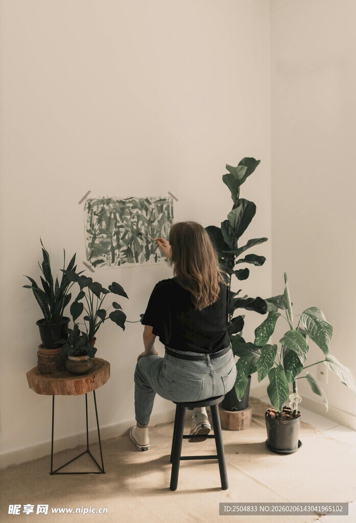 女子专注于室内绿植绘画