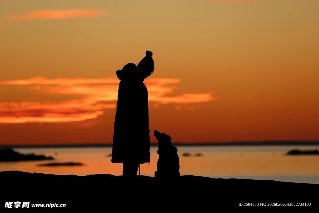 夕阳下人与狗的温馨剪影