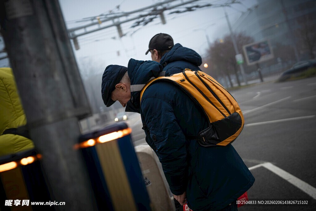雨中父子撑伞低头前行