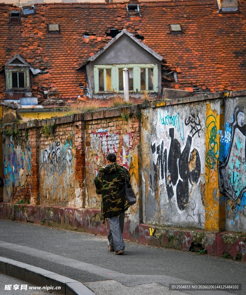 街头行人旁的多彩涂鸦墙