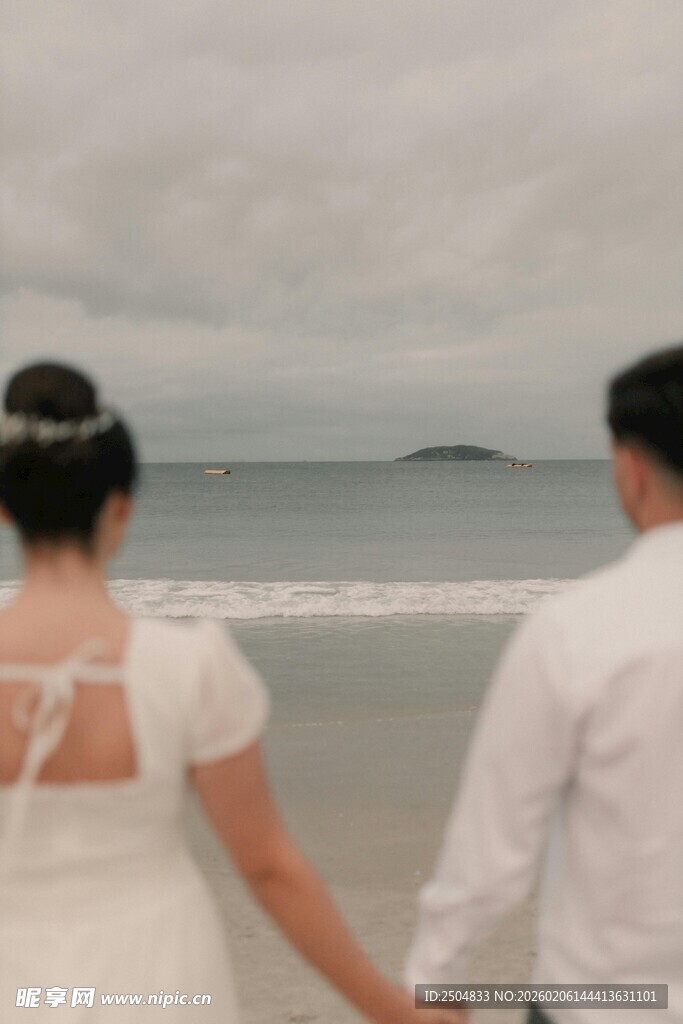 海边牵手的新婚夫妇
