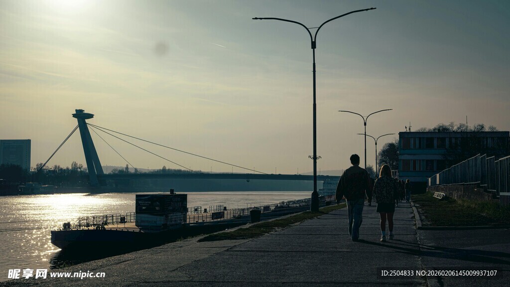 夕阳下的河畔行人景致