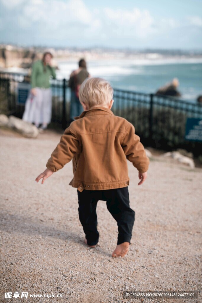 沙滩上蹒跚学步的可爱宝宝