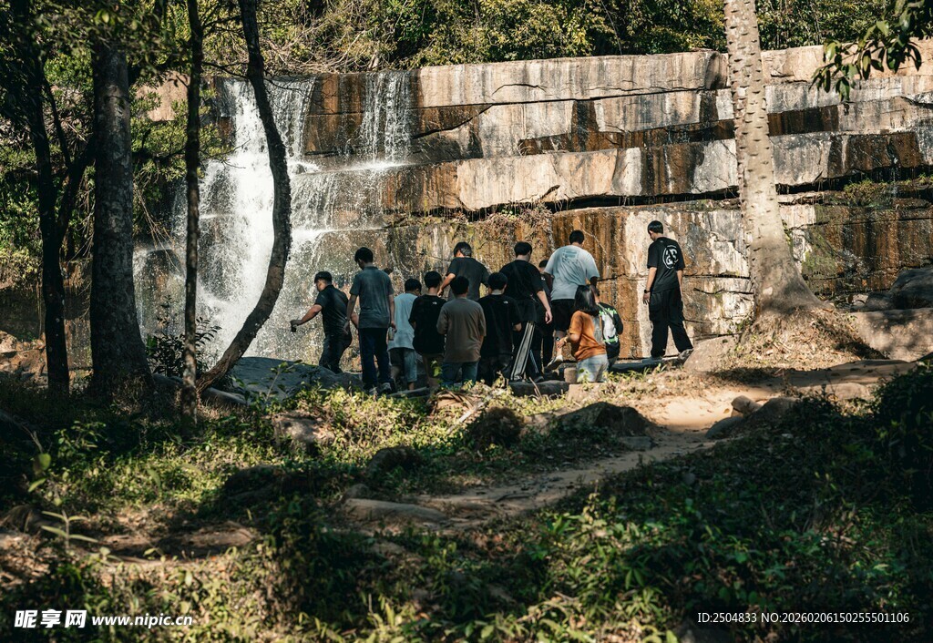 户外人群赏景于瀑布旁