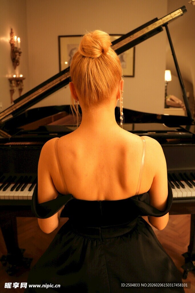 女子背对镜头专注弹钢琴