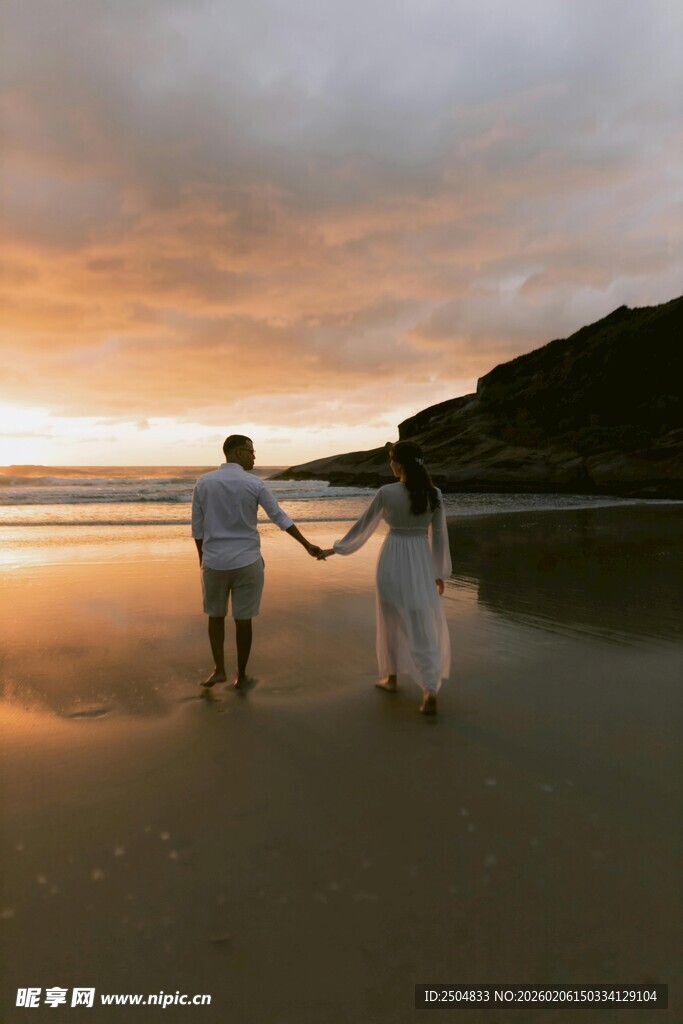 夕阳下情侣漫步海滩