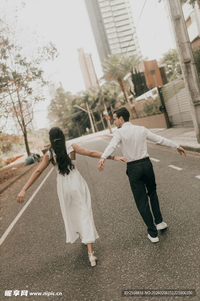 情侣街头牵手漫步背影