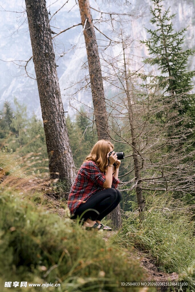 森林中专注拍照的女性