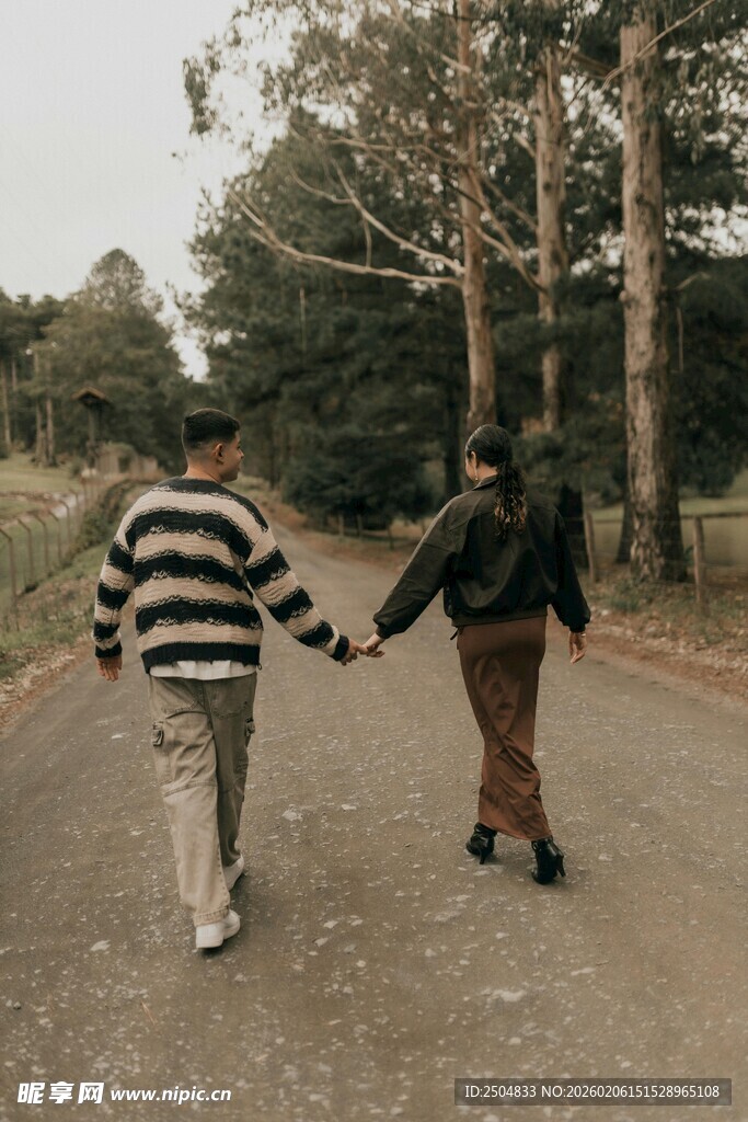 林间牵手漫步的两人