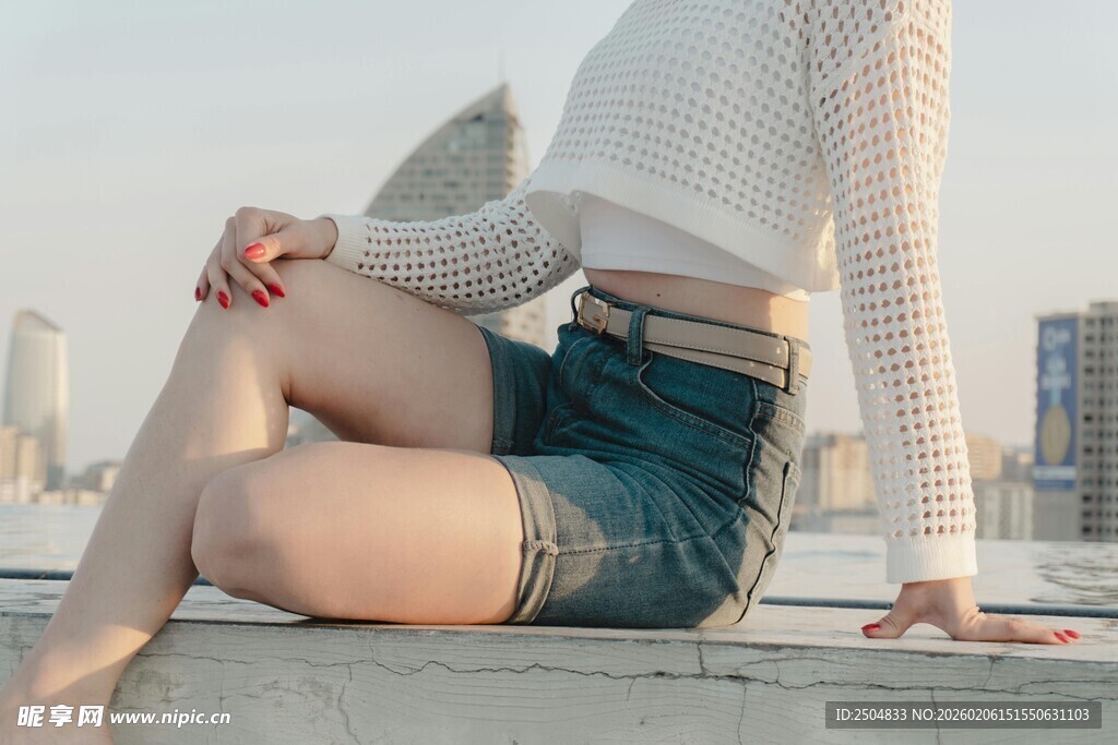 时尚女孩坐于城市天台