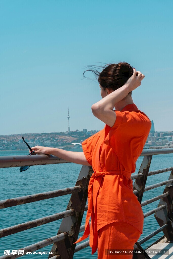 海边红衣女子惬意抚发