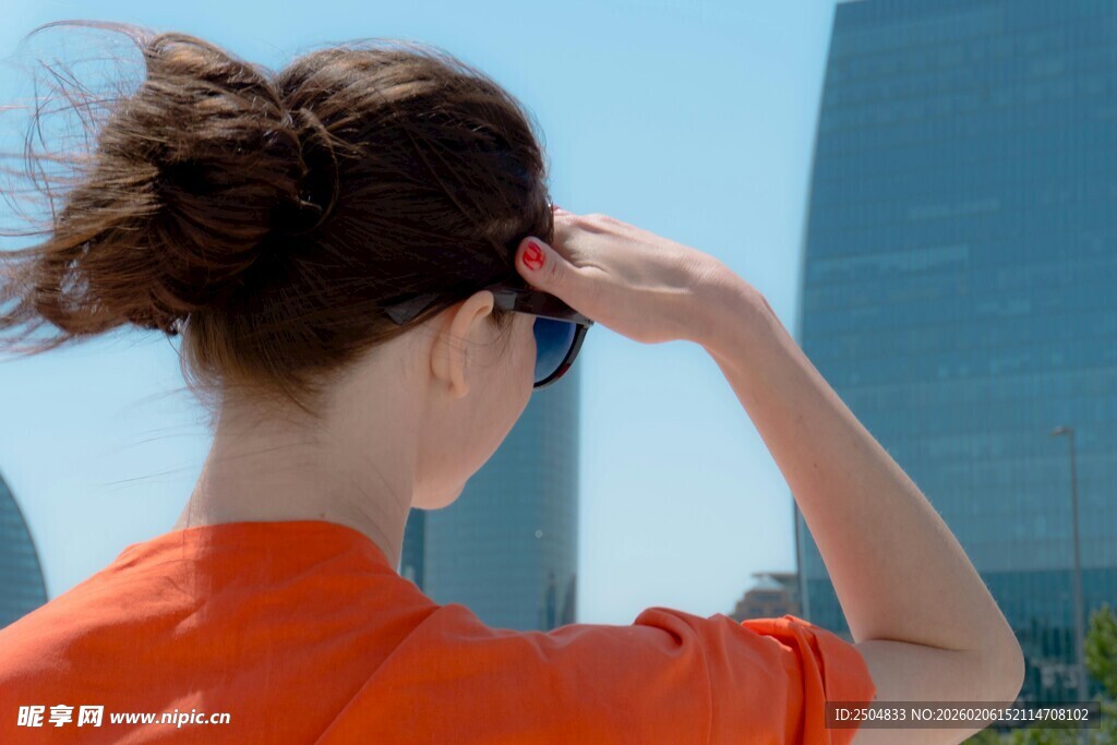 红衣女子背对远眺高楼