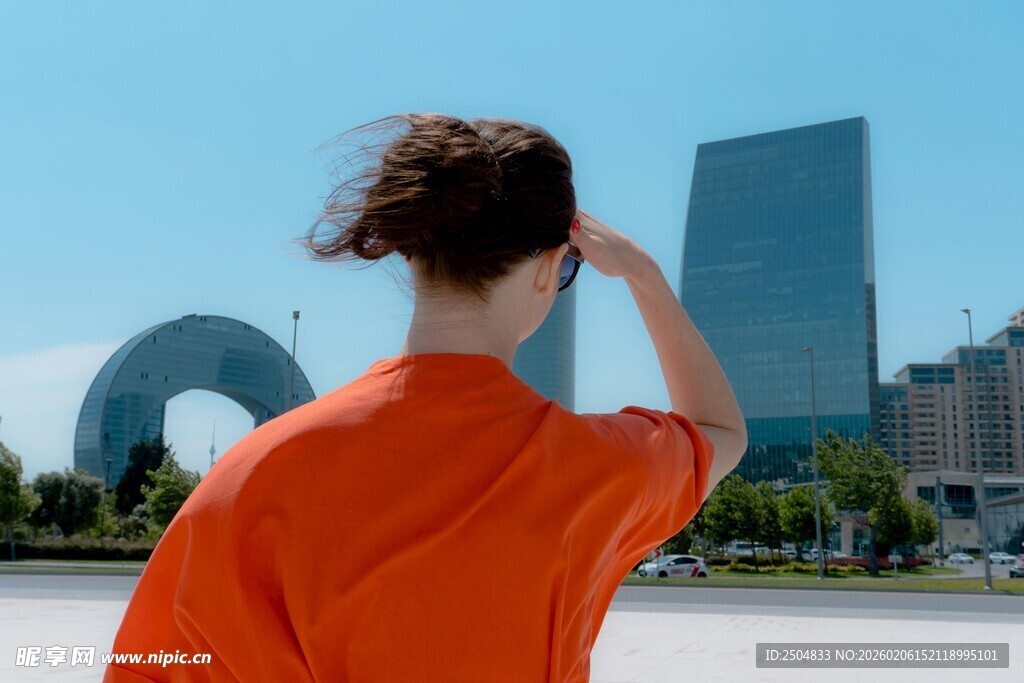 红衣女子眺望城市建筑