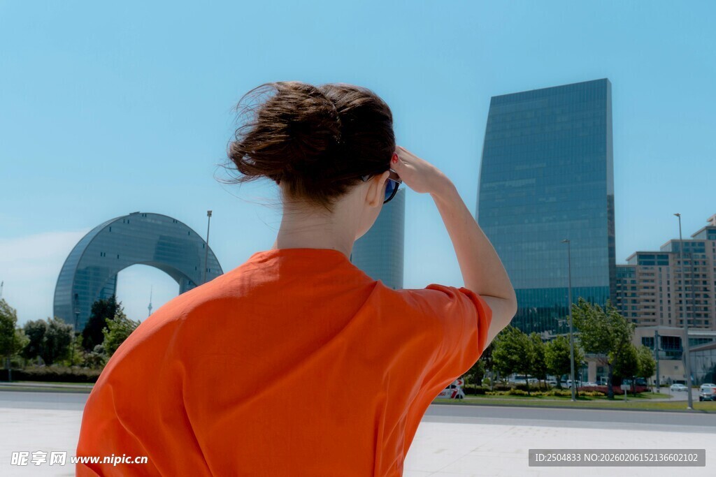 红衣女子眺望城市建筑