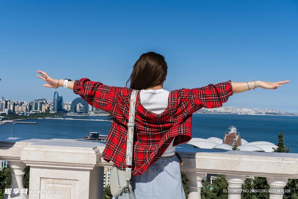 女孩临海张开双臂赏景