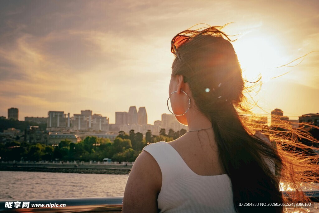 夕阳下女孩背对城市美景