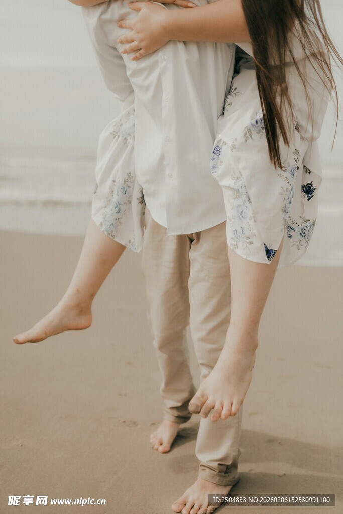 父亲海边背女儿温馨时刻