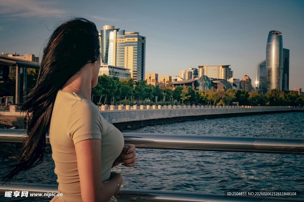 女子河畔眺望城市天际线