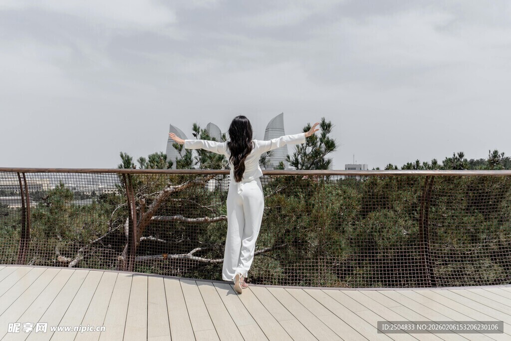 白衣女子于露台眺望远方