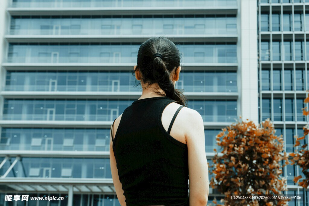 女子背对高楼而立